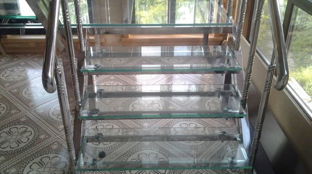 Лестница со стеклянными ступенями из прозрачного ламинированного стекла, каркас лестницы - кованный металл