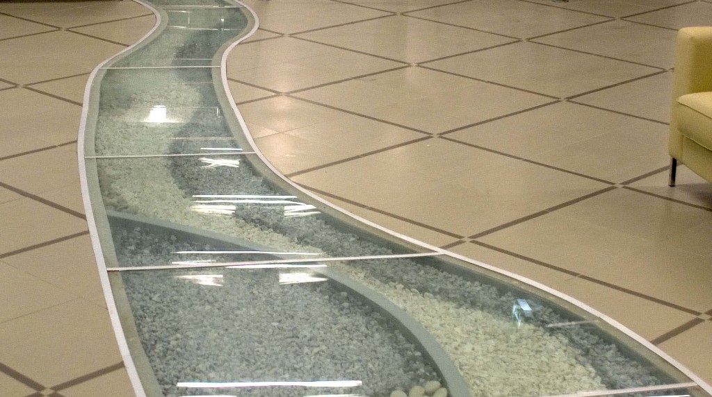 Пол из стекла встроенный в пол с покрытием из плитки, основание из фибробетона, имитация ручья с наполнением галькой, бизнес-центр